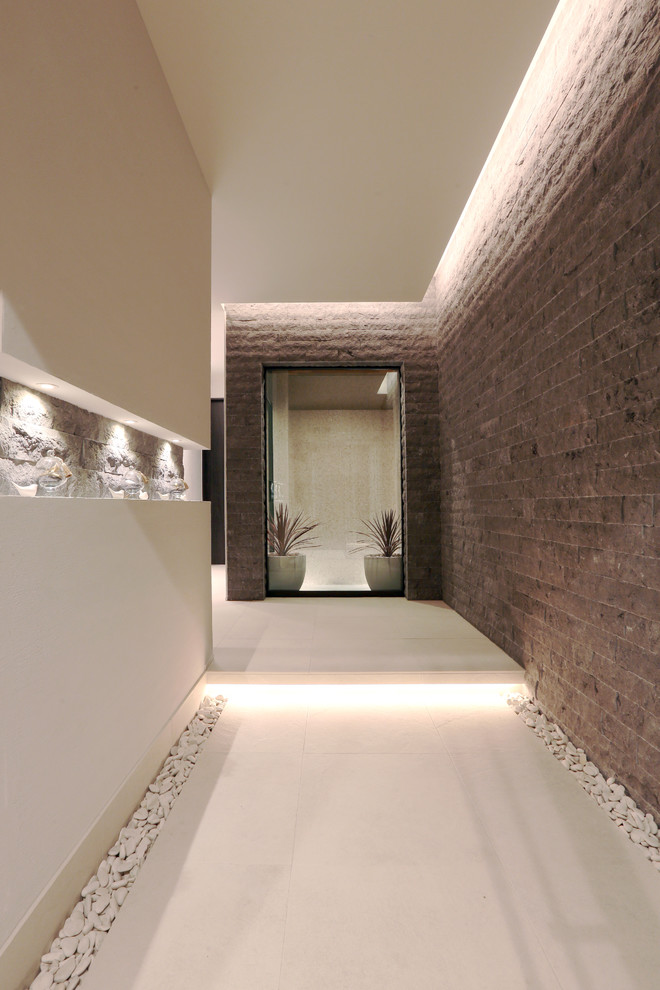 Foto di un corridoio minimalista di medie dimensioni con pareti multicolore, pavimento in terracotta, una porta singola, una porta in legno scuro e pavimento bianco