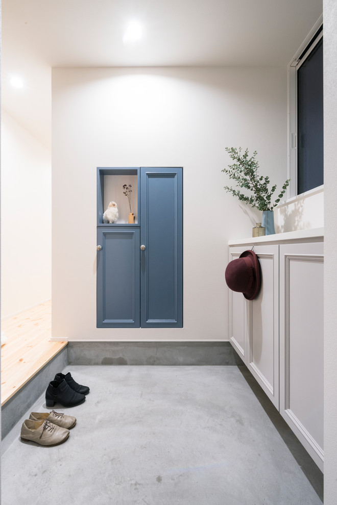 Diseño de hall nórdico con paredes blancas, suelo de cemento y suelo gris