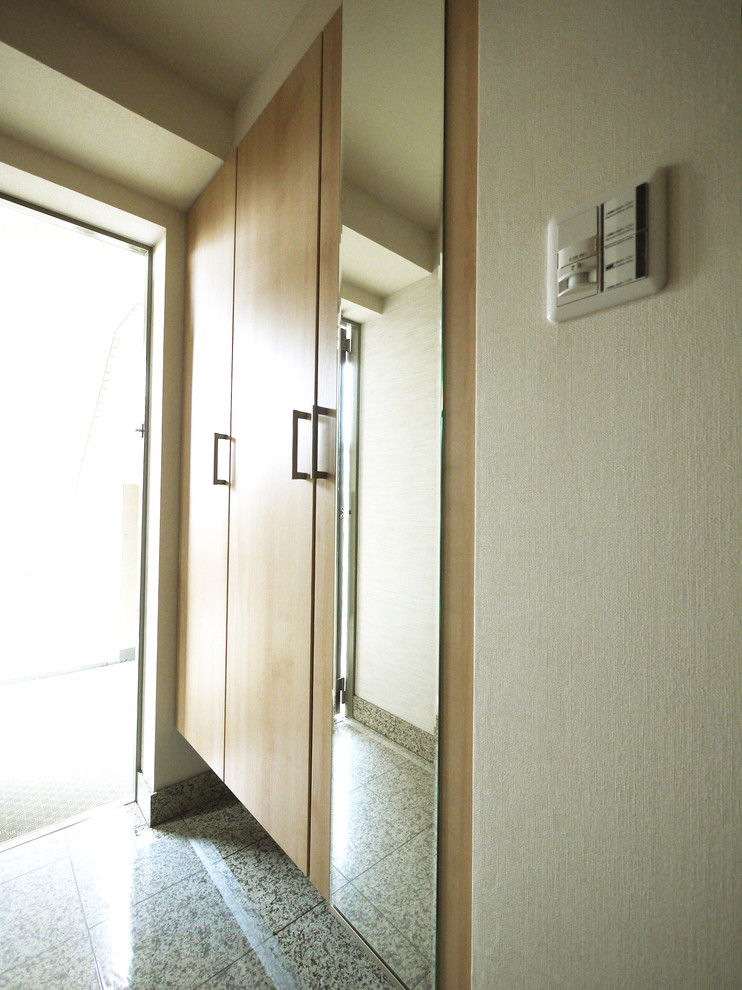 Cette photo montre une entrée asiatique avec un couloir, un mur beige, un sol en marbre, une porte coulissante et un sol gris.