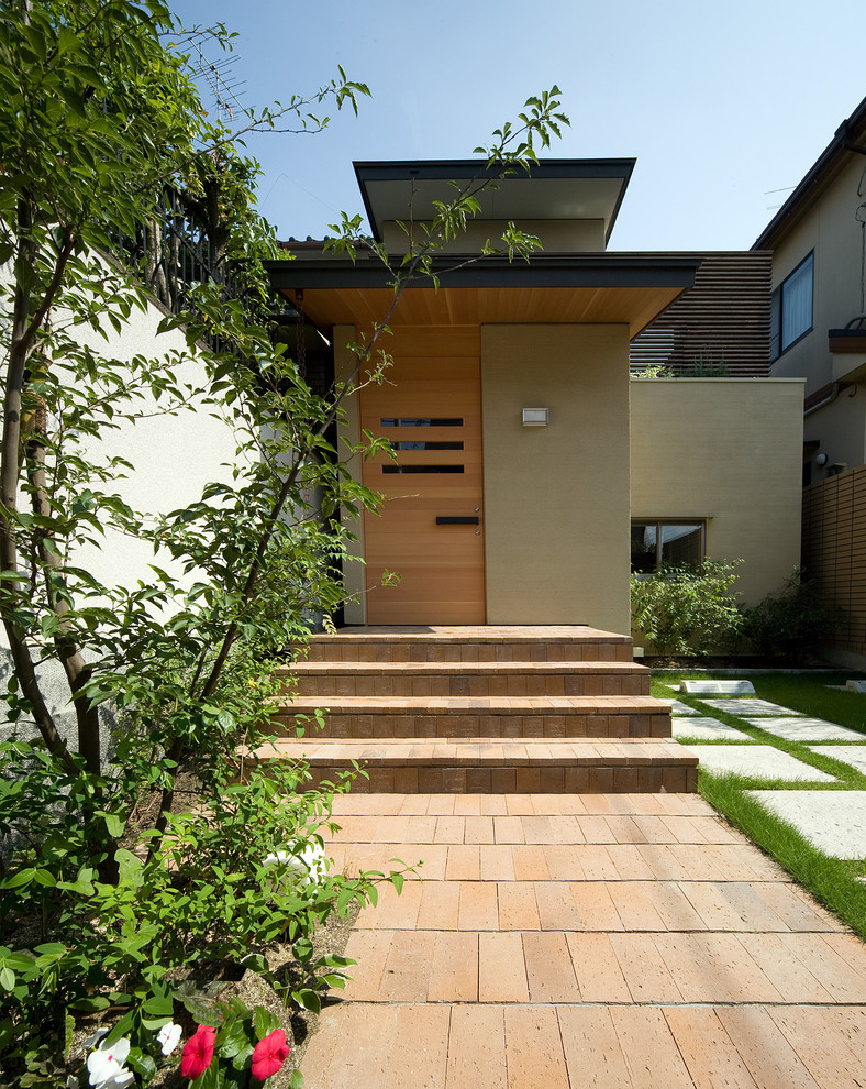 Inspiration for a world-inspired entrance in Kyoto with a single front door and a light wood front door.