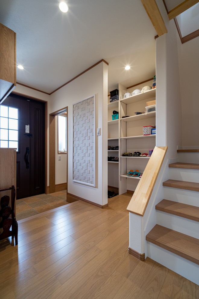 Foyer mit weißer Wandfarbe, Sperrholzboden, Einzeltür, brauner Haustür, braunem Boden, Tapetendecke und Tapetenwänden in Sonstige