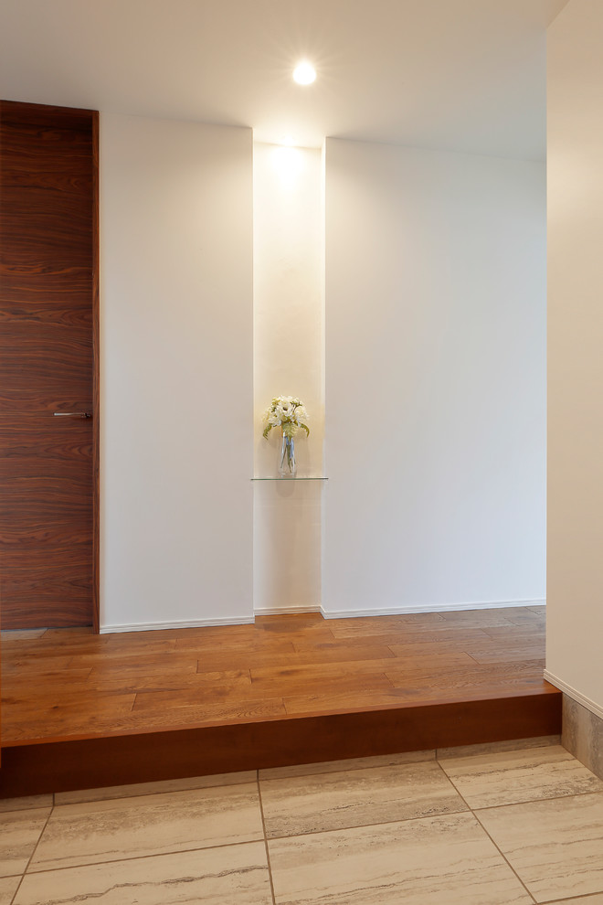 Foto de hall de estilo zen con paredes blancas, suelo de madera en tonos medios y suelo marrón