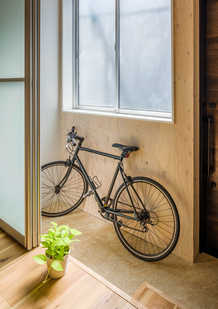 На фото: фойе среднего размера в скандинавском стиле с бежевыми стенами, полом из терраццо, раздвижной входной дверью, коричневой входной дверью, бежевым полом, деревянным потолком и деревянными стенами