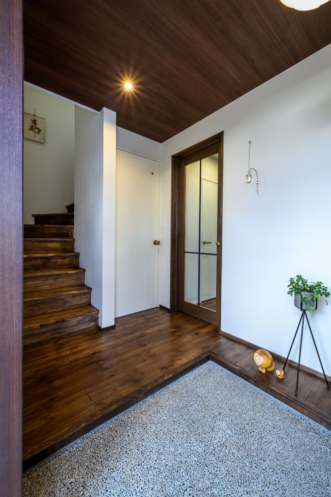 Idee per un ingresso con una porta singola, una porta in legno scuro, pavimento marrone, pareti grigie e parquet scuro