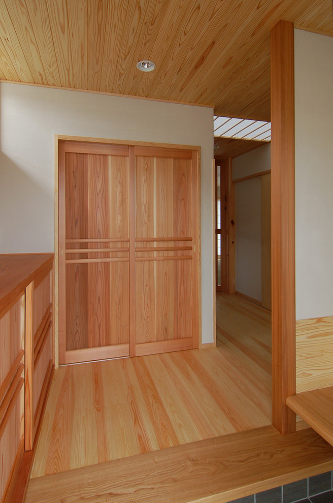 他の地域にある和風のおしゃれな玄関 (白い壁、淡色無垢フローリング、濃色木目調のドア、ベージュの床) の写真