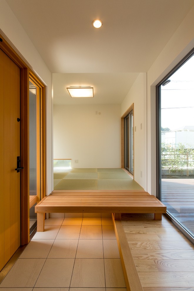 World-inspired hallway in Tokyo Suburbs with white walls, a single front door, a medium wood front door, brown floors, medium hardwood flooring, a wallpapered ceiling and wallpapered walls.