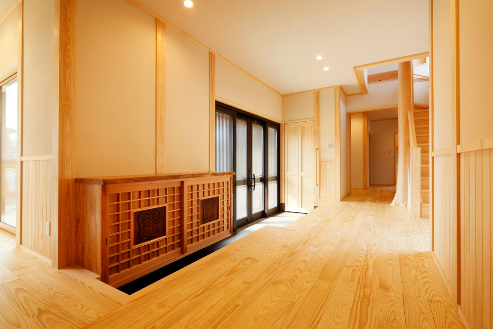 Asiatischer Eingang mit brauner Wandfarbe, braunem Holzboden, Doppeltür und braunem Boden in Sonstige