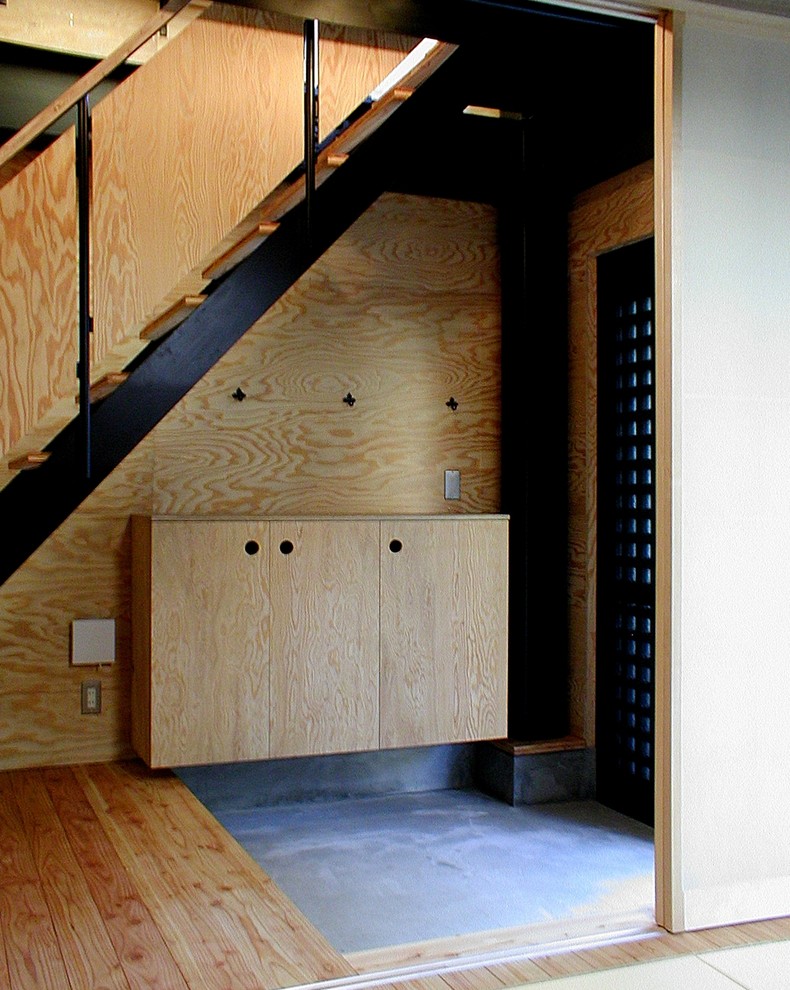 Idee per un piccolo corridoio industriale con pareti marroni, pavimento in cemento, una porta scorrevole, una porta nera e pavimento grigio