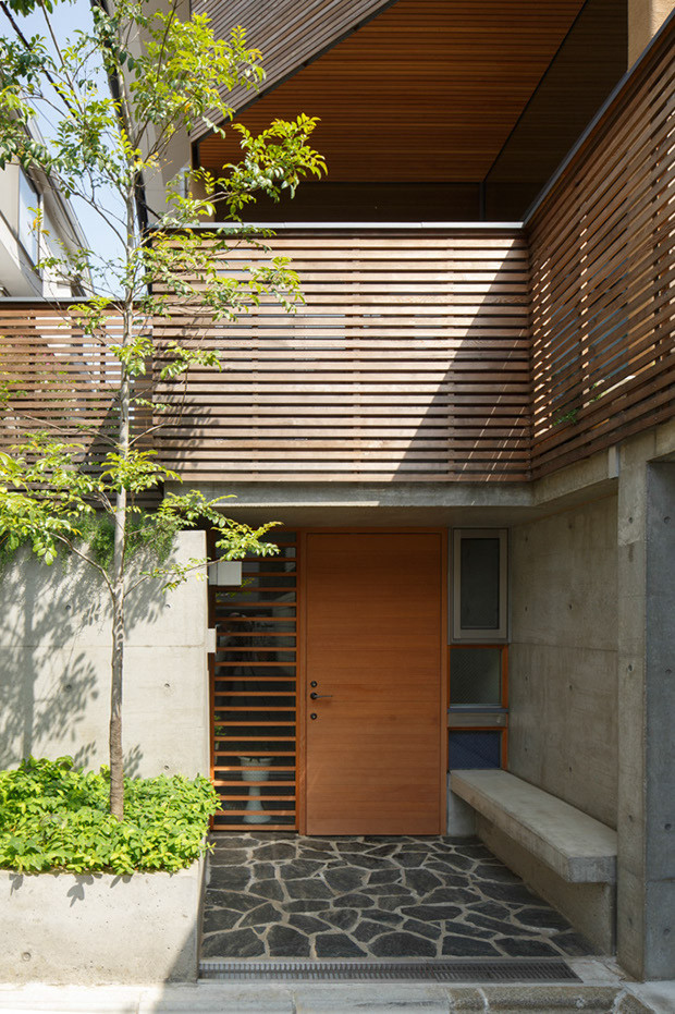 Foto de puerta principal moderna de tamaño medio con paredes grises, suelo de mármol, puerta simple, puerta de madera en tonos medios y suelo gris