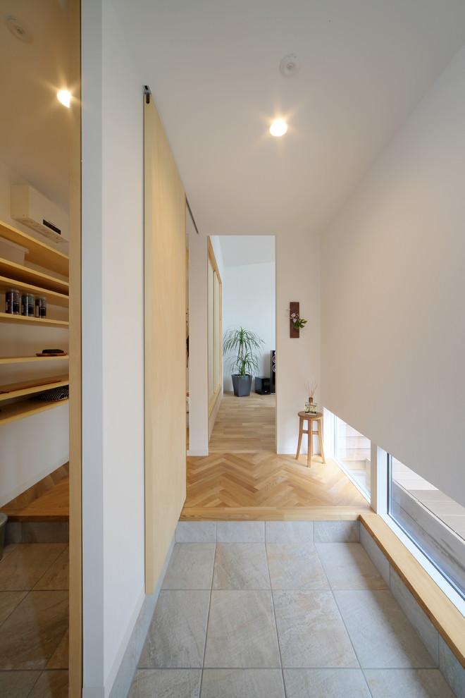Diseño de hall minimalista con paredes blancas y suelo gris