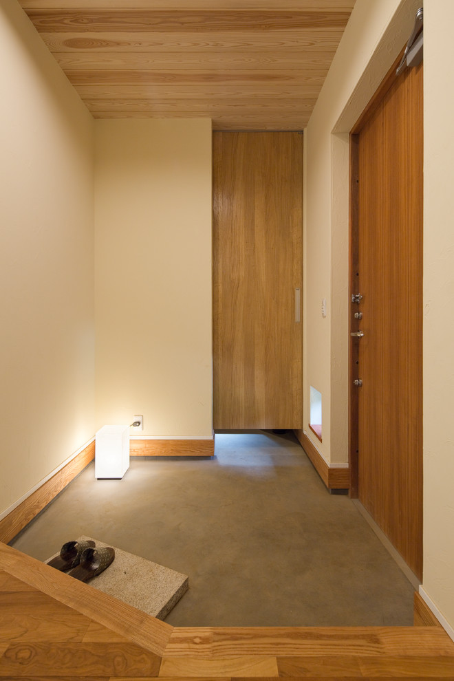 Foto di un piccolo corridoio moderno con pareti bianche, pavimento in legno massello medio, una porta singola, una porta in legno bruno e soffitto in legno