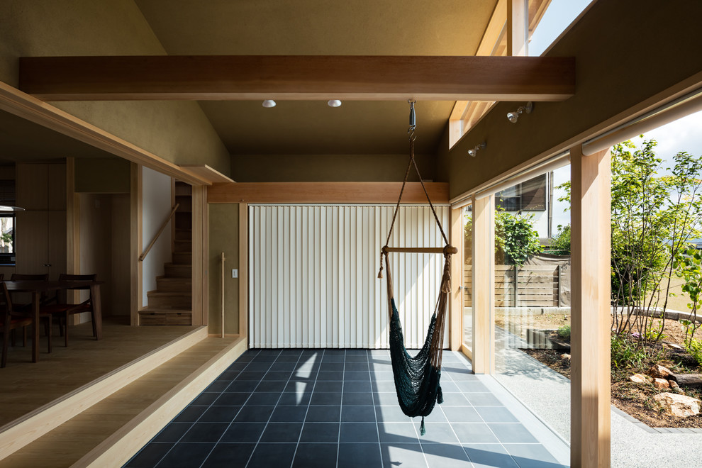 Inspiration for a zen black floor entryway remodel in Other with beige walls and a light wood front door