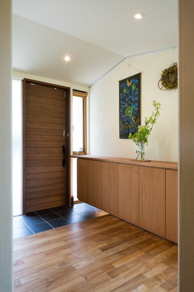 Foto di un corridoio country di medie dimensioni con pareti bianche, pavimento in gres porcellanato, una porta singola, una porta in legno bruno e pavimento nero