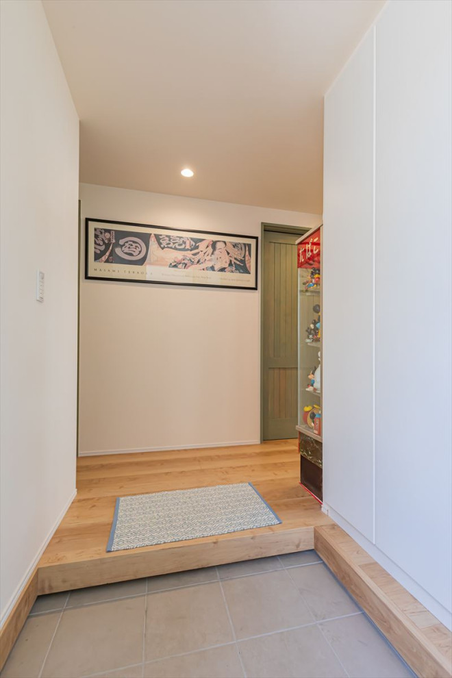 Imagen de hall moderno de tamaño medio con puerta simple, paredes blancas, puerta verde, suelo gris, suelo de baldosas de porcelana, papel pintado y madera