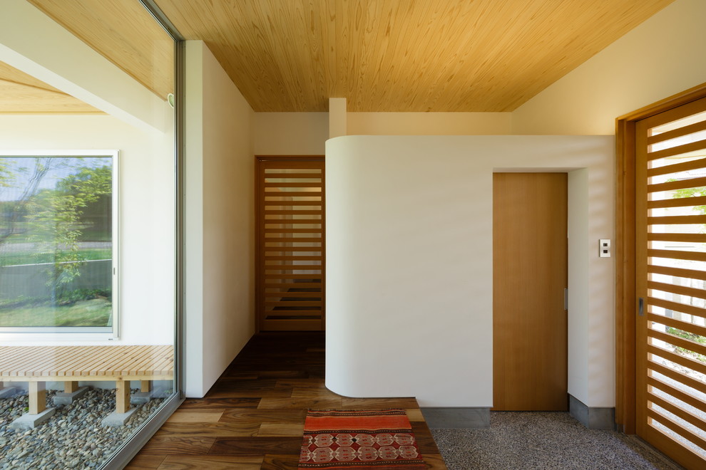 他の地域にあるコンテンポラリースタイルのおしゃれな玄関 (白い壁、無垢フローリング、茶色い床) の写真