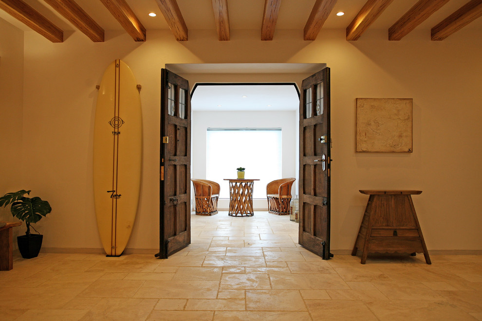 Modelo de hall blanco mediterráneo con paredes blancas, suelo de mármol, puerta simple, puerta azul, suelo beige y vigas vistas