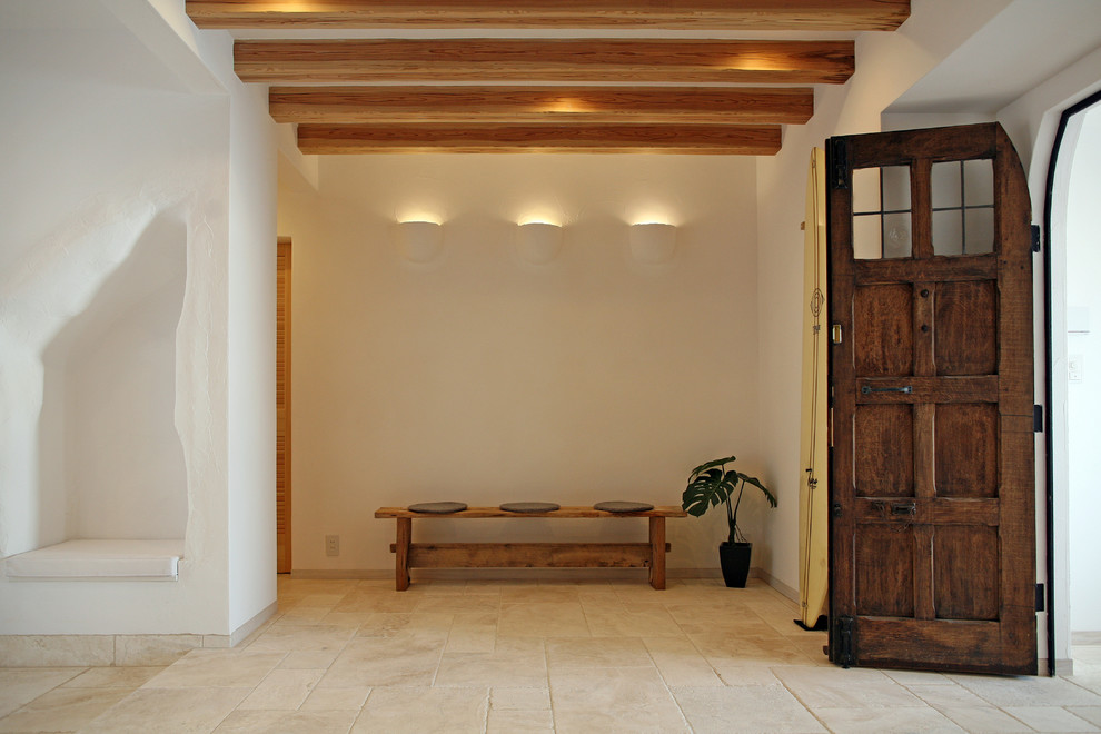 Imagen de hall blanco mediterráneo con paredes blancas, suelo de mármol, puerta simple, puerta azul, suelo beige y vigas vistas