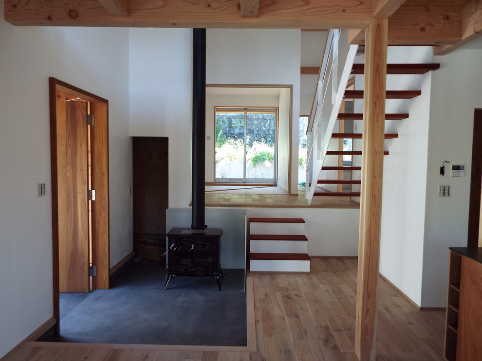 Источник вдохновения для домашнего уюта: узкая прихожая в стиле кантри с белыми стенами, бетонным полом, одностворчатой входной дверью, входной дверью из дерева среднего тона и черным полом