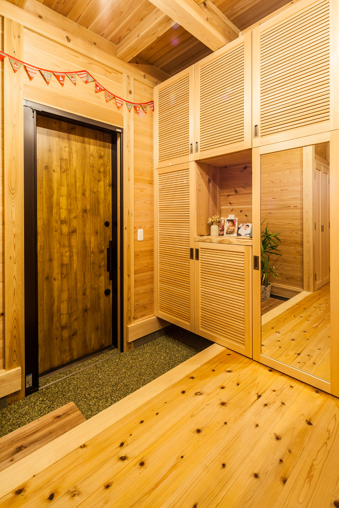 Imagen de hall costero con paredes marrones, puerta simple y puerta de madera en tonos medios