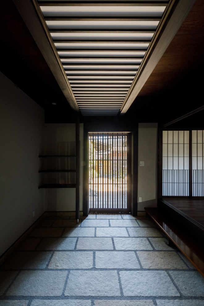 大阪にある高級な広いトラディショナルスタイルのおしゃれな玄関ホール (白い壁、御影石の床、茶色いドア、ベージュの床、板張り天井) の写真