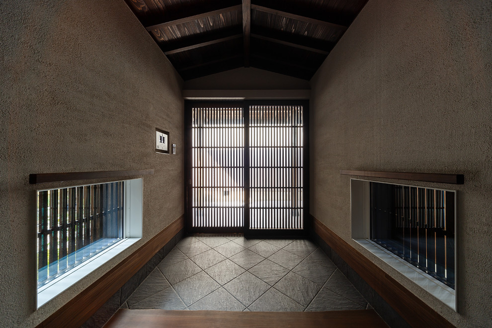 Kleiner Asiatischer Eingang mit Korridor, weißer Wandfarbe, Porzellan-Bodenfliesen, Schiebetür, schwarzer Haustür und grauem Boden in Kobe