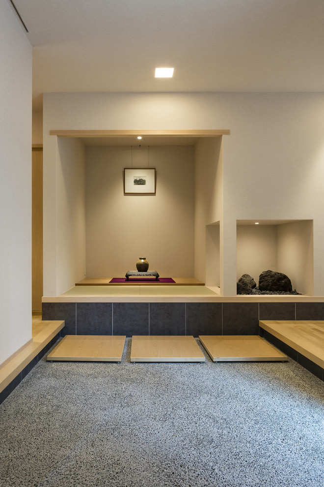 神戸にあるアジアンスタイルのおしゃれな玄関 (白い壁、グレーの床) の写真