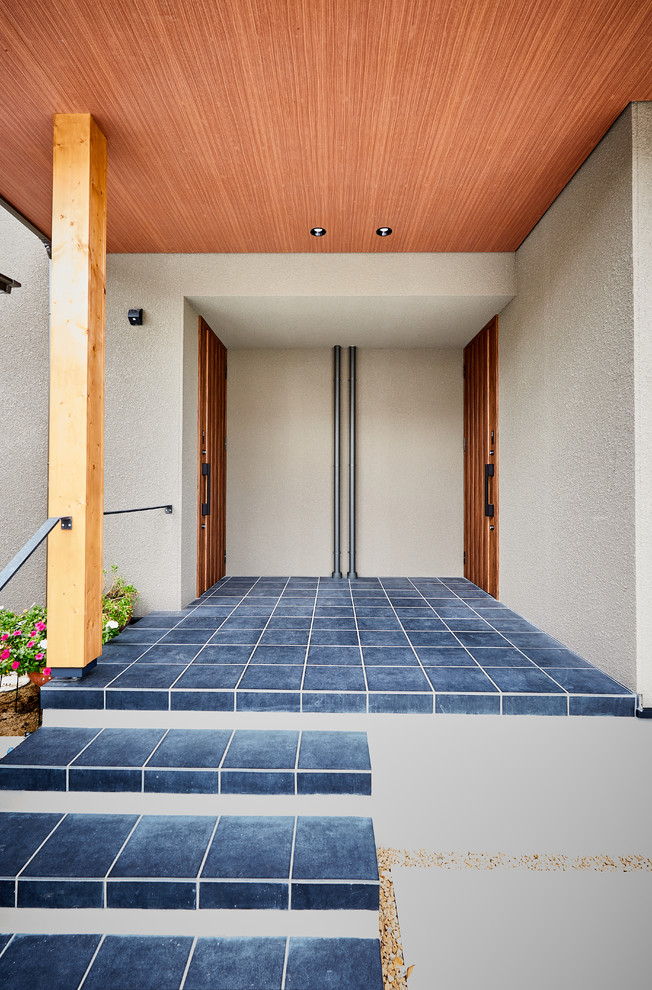 Diseño de entrada actual con paredes grises, suelo de baldosas de porcelana, puerta simple, puerta de madera en tonos medios y suelo gris
