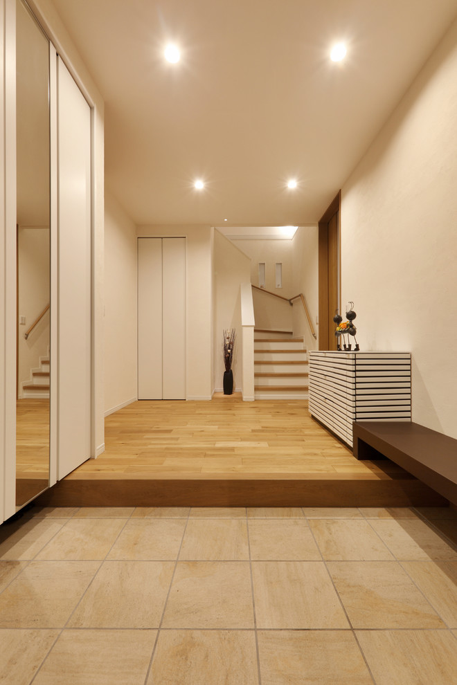 Photo of a world-inspired hallway in Other with white walls and beige floors.