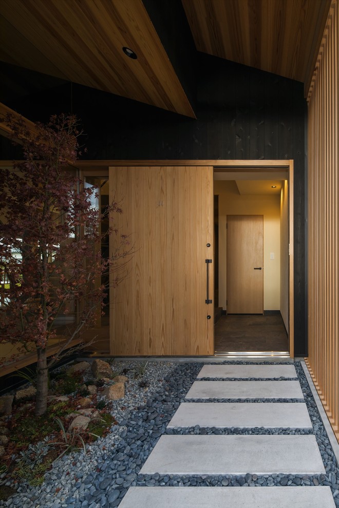 Inspiration pour une porte d'entrée asiatique de taille moyenne avec un mur beige, une porte coulissante, une porte en bois clair et un sol beige.