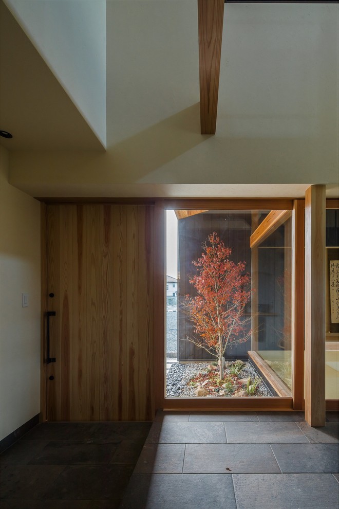Imagen de hall asiático de tamaño medio con paredes beige, suelo de madera en tonos medios, puerta corredera, puerta de madera clara y suelo beige