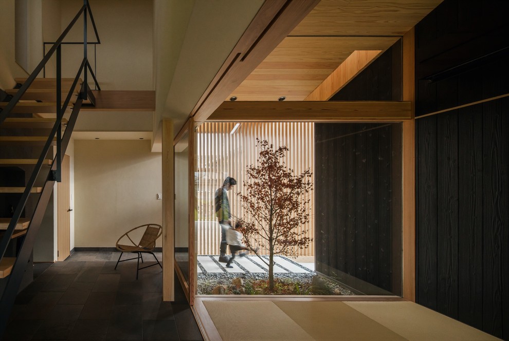 Diseño de puerta principal de estilo zen de tamaño medio con paredes beige, suelo de madera en tonos medios, puerta corredera, puerta de madera clara y suelo beige