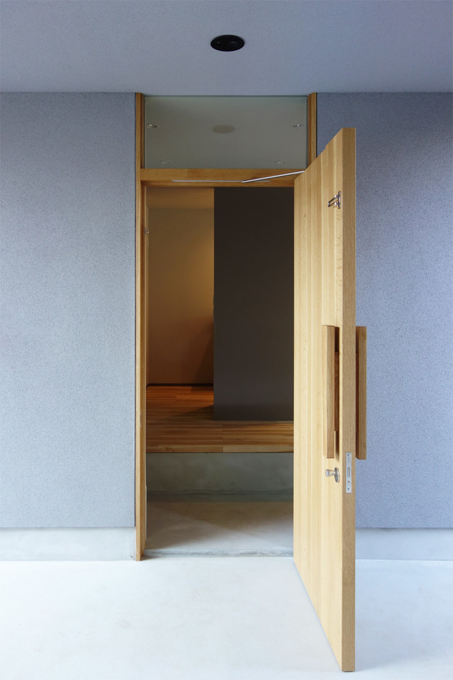 Moderne Haustür mit grauer Wandfarbe, Betonboden, Einzeltür, heller Holzhaustür und grauem Boden in Tokio