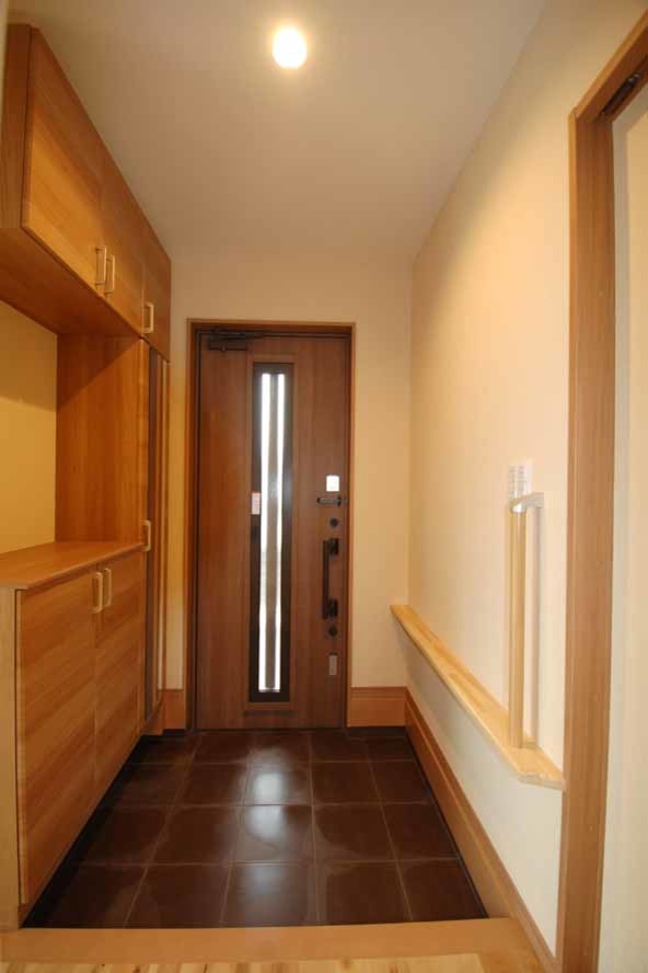 Foto de entrada de estilo zen de tamaño medio con paredes blancas, suelo de baldosas de terracota, puerta simple, puerta de madera en tonos medios y suelo marrón