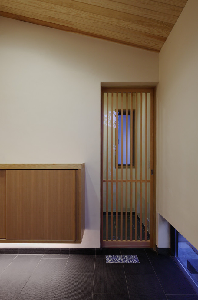 Asian porcelain tile entryway photo in Tokyo Suburbs with white walls and a dark wood front door