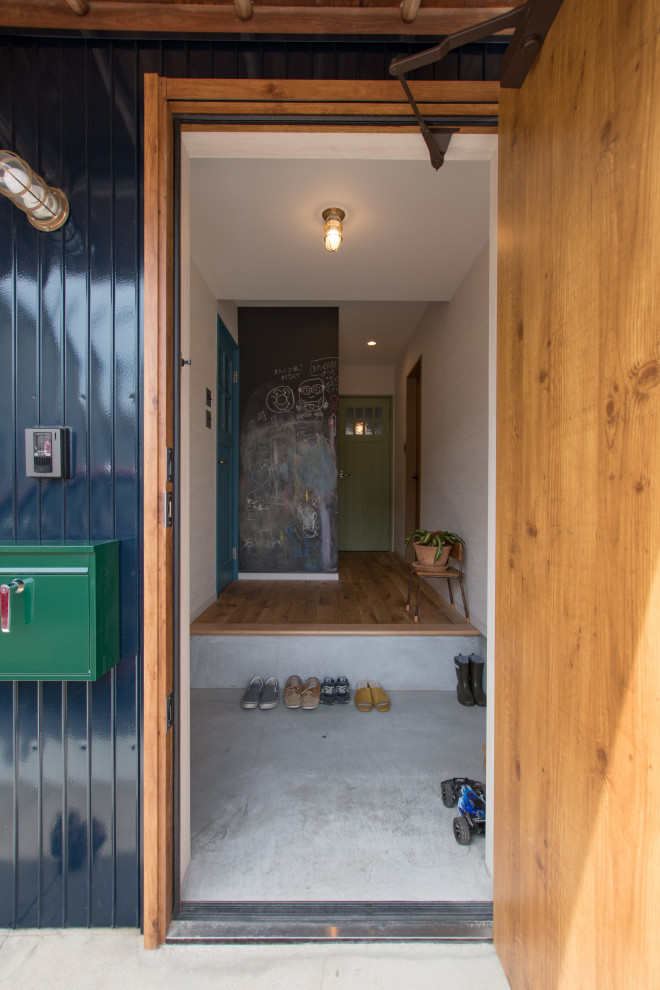 Kleiner Stilmix Eingang mit Korridor, weißer Wandfarbe, braunem Holzboden, Einzeltür, hellbrauner Holzhaustür, braunem Boden, Tapetendecke und Tapetenwänden in Sonstige