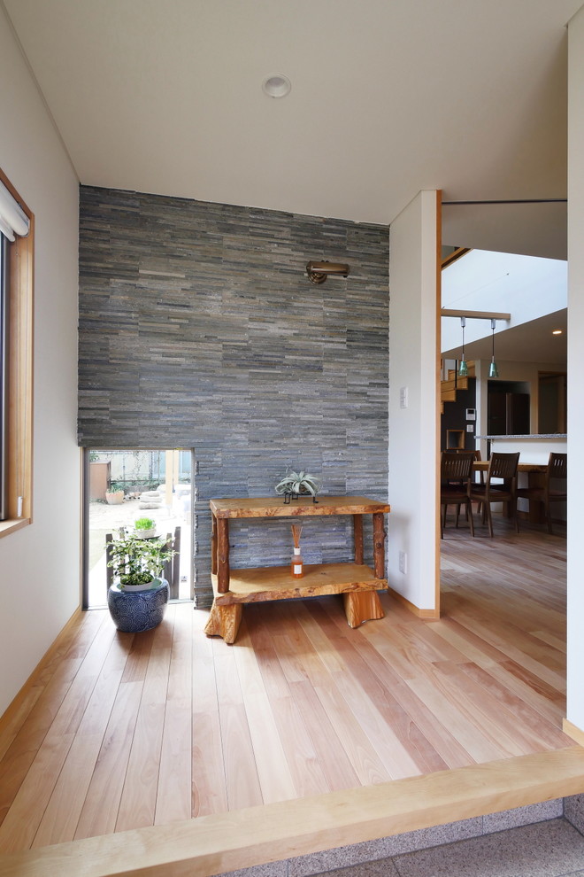 Imagen de entrada de estilo zen con paredes blancas, suelo de madera clara y suelo marrón