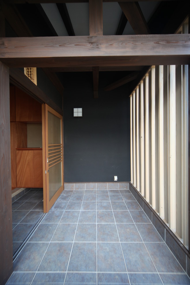 Свежая идея для дизайна: входная дверь среднего размера в восточном стиле с черными стенами, полом из керамической плитки, раздвижной входной дверью, входной дверью из дерева среднего тона и серым полом - отличное фото интерьера