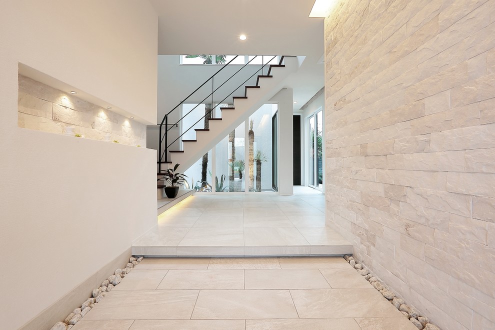 Esempio di un grande corridoio moderno con pareti bianche, pavimento in terracotta, una porta singola, pavimento bianco e una porta marrone