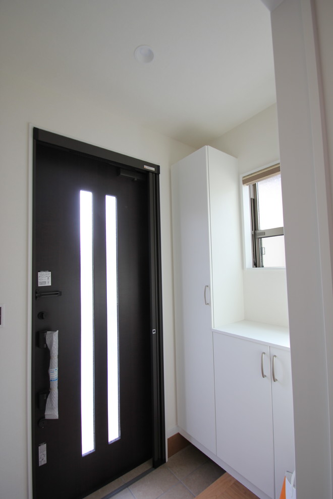 Exemple d'une entrée moderne avec un mur blanc, un sol en contreplaqué, une porte simple, un couloir, une porte marron et un sol marron.