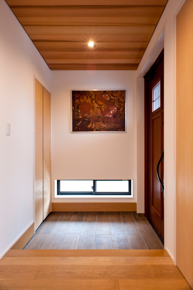 На фото: прихожая в стиле неоклассика (современная классика) с белыми стенами, паркетным полом среднего тона, одностворчатой входной дверью, входной дверью из дерева среднего тона и коричневым полом с