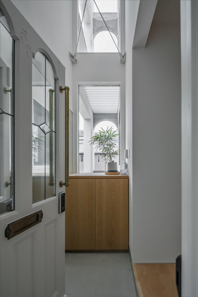 Ejemplo de hall nórdico de tamaño medio con paredes blancas, suelo de madera en tonos medios, puerta simple, puerta blanca y suelo beige