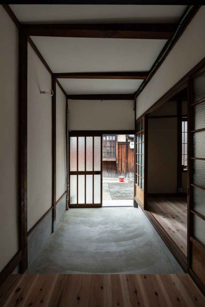 Kleiner Klassischer Eingang mit Korridor, weißer Wandfarbe, Betonboden, Schiebetür, heller Holzhaustür, grauem Boden, Holzdielendecke und Holzdielenwänden in Kyoto