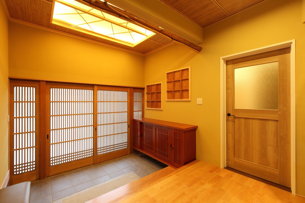 Example of an entryway design in Other with brown walls and a medium wood front door