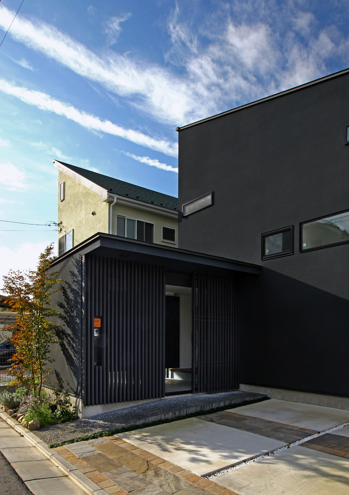 На фото: прихожая среднего размера в восточном стиле с черными стенами, раздвижной входной дверью и стеклянной входной дверью с