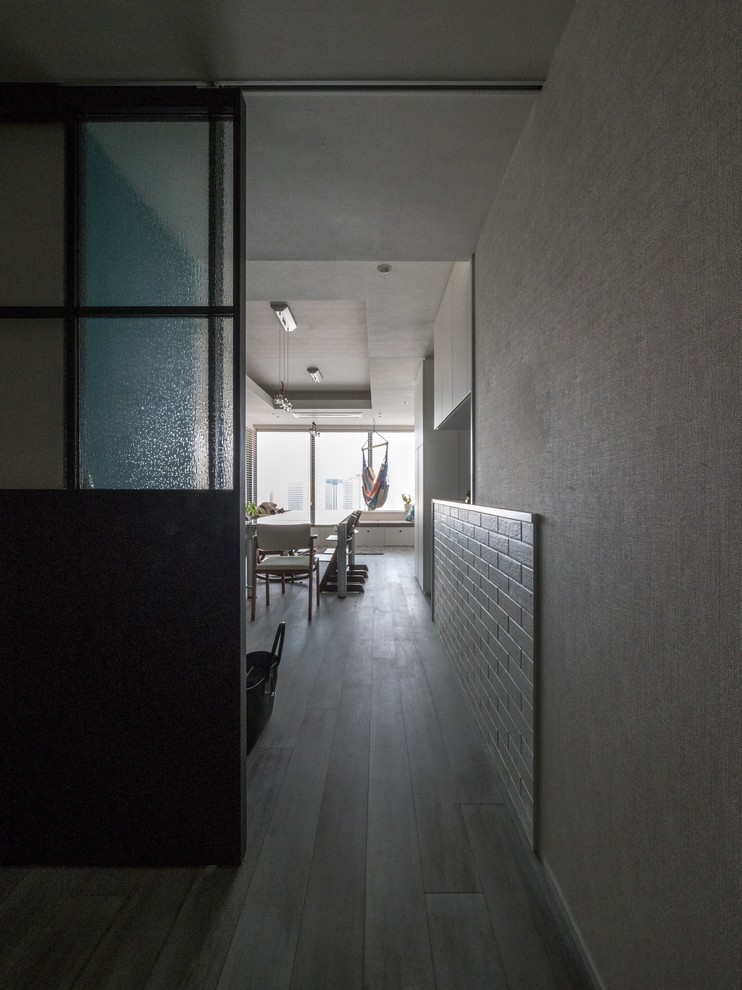 Diseño de entrada contemporánea con paredes blancas, suelo de madera en tonos medios y suelo gris