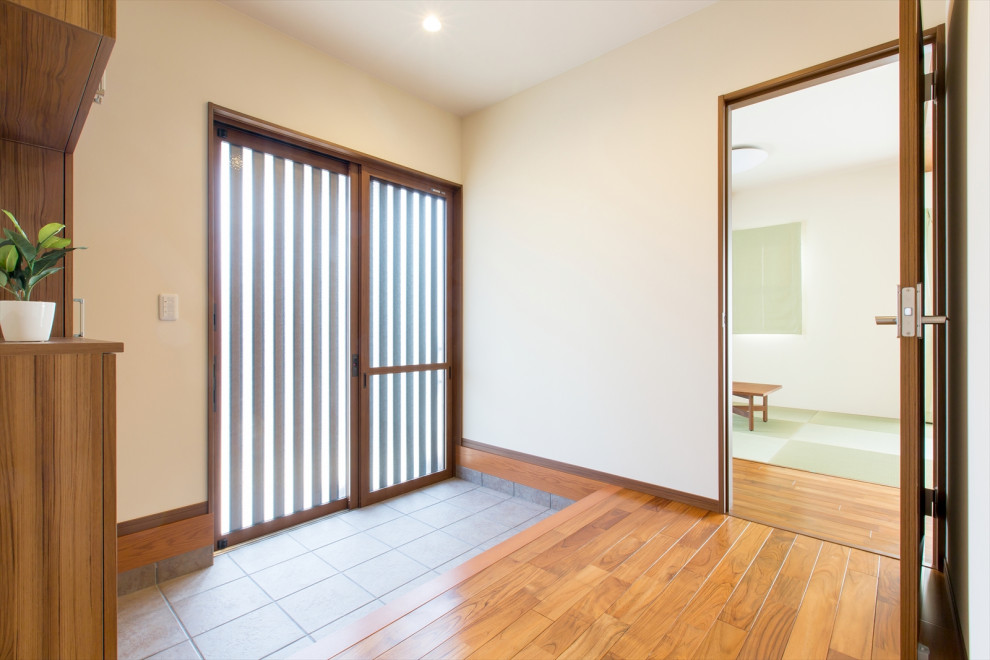 Photo of a medium sized world-inspired hallway in Other with white walls, dark hardwood flooring, a sliding front door, a brown front door and brown floors.