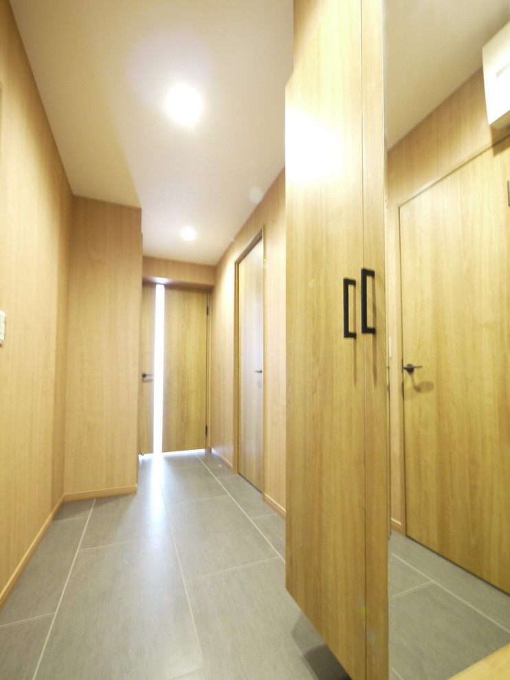 Esempio di un ingresso o corridoio moderno con pareti beige, pavimento con piastrelle in ceramica, una porta singola, una porta grigia e pavimento grigio