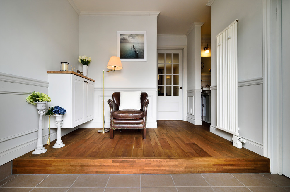 Esempio di un corridoio chic con pareti bianche, pavimento in legno massello medio e pavimento marrone