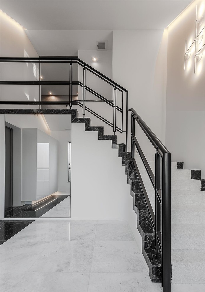 Inspiration for a modern hallway with white walls, a black front door and white floors.