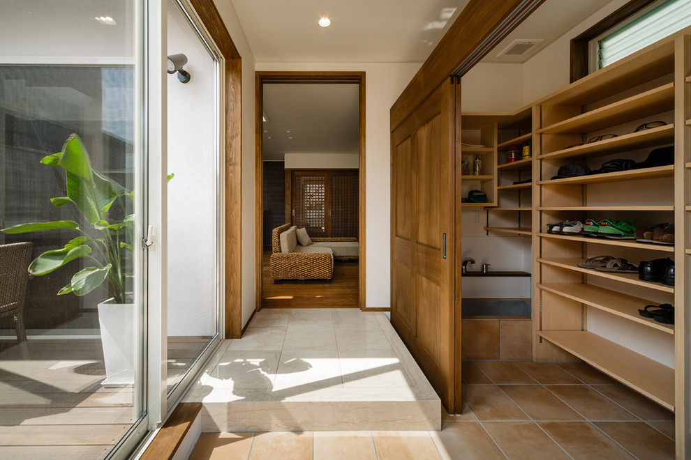 Modelo de hall de estilo zen con paredes blancas, suelo de baldosas de terracota y suelo naranja